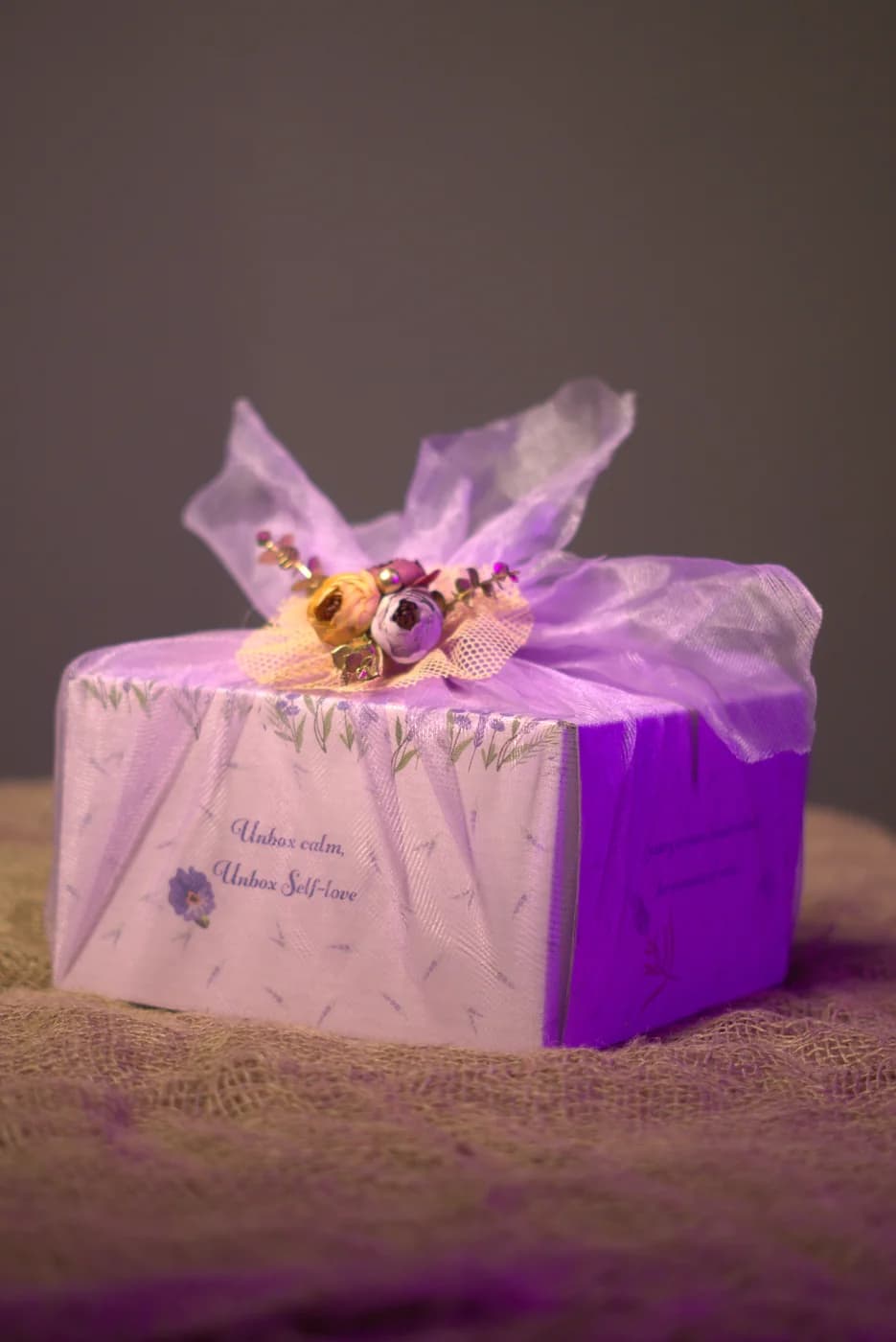 Gift box wrapped in lilac tulle with a dried-flower posy