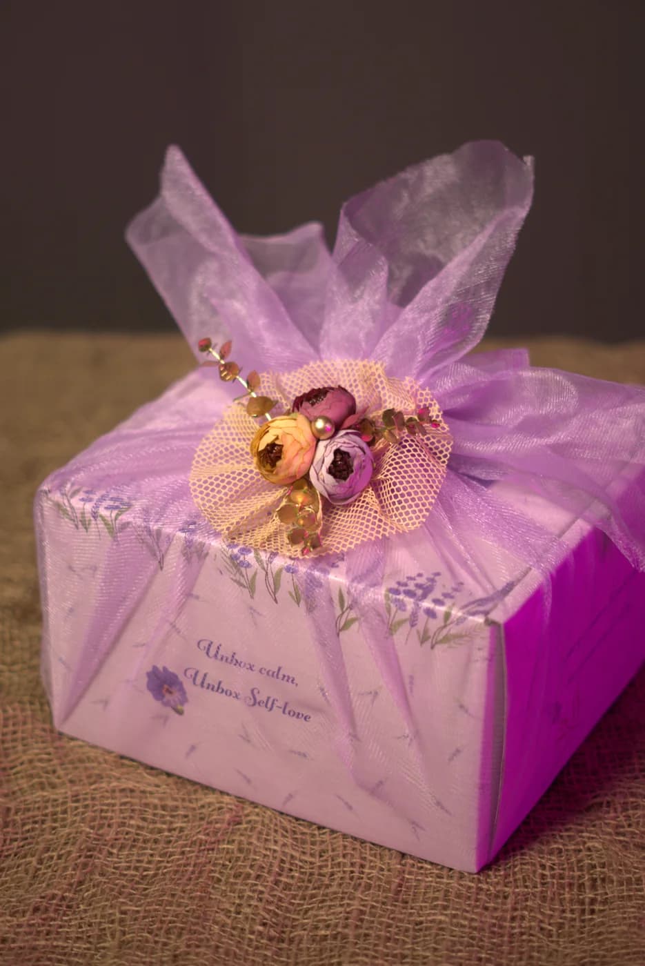 Gift box wrapped in lilac tulle with a dried-flower posy